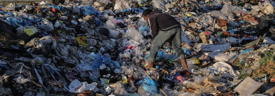 بالصور:بحثاً عن لقمة عيشه..فلسطيني يجمع البلاستيك ومواد قابلة للاستخدام  من مكب للنفايات في بلدة بيت لاهيا  شمال قطاع غزة