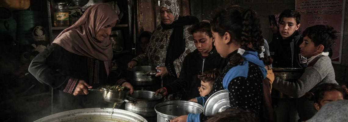 امرأة غزية تحاول تدفئة بطون الفقراء في غزة بـ"التكية"