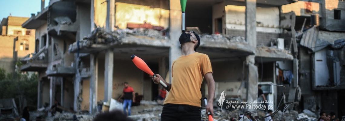 من فوق ركام المنازل  شاب يتطوع للترفيه عن الأطفال في بيت حانون
