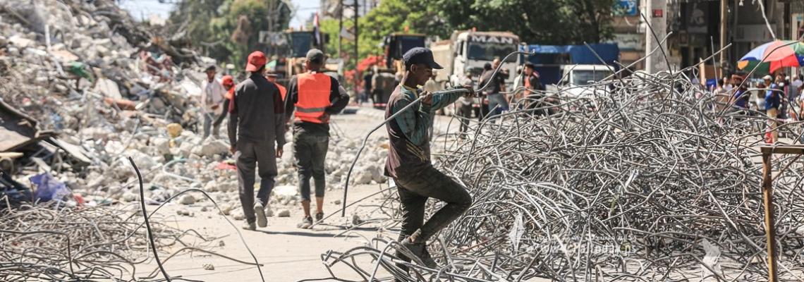 بالصور :عمال في غزة يُعيدون تدوير "حديد الأبراج السكنية" التي دمرها الاحتلال الإسرائيلي خلال معركة سيف القدس
