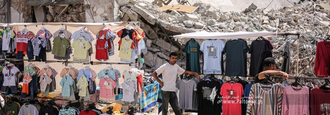بالصور:فلسطينيون يفتتحون بسطات فوق الدمار لبيع الملابس استعدادًا لعيد الأضحى المبارك
