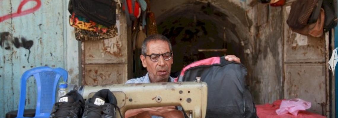 الخياط خليل حمدان يُعيد خياطة الأحذية والحقائب البالية للطلاب قبل بداية العام الدراسي الجديد