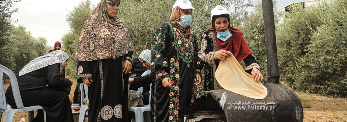 بالصور:فلسطينيات يعددن الخبز على الصاج  خلال افتتاح موسم جني الزيتون بغزة