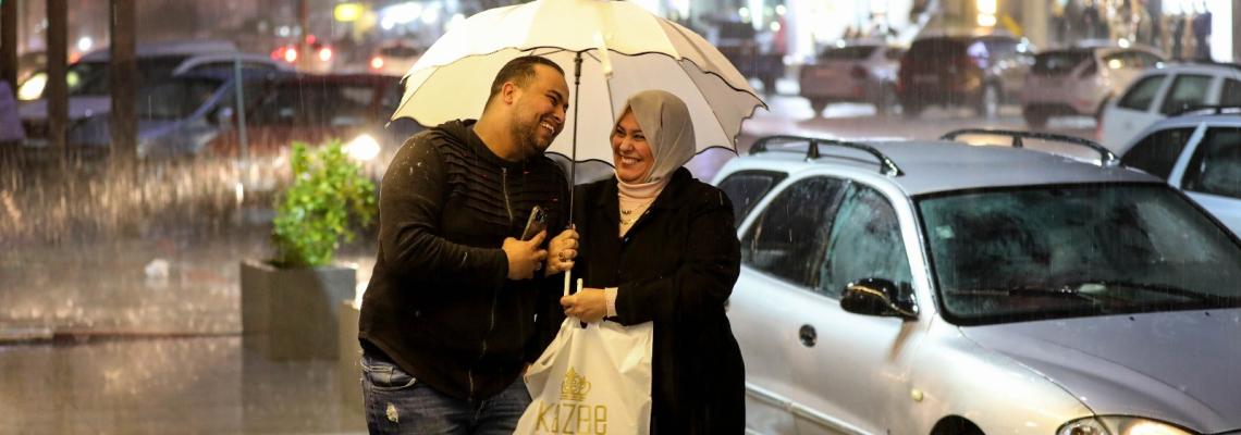 تحت زخات المطر.. مواطنون يتجولون في حي الرمال وسط مدينة غزة مساء اليوم