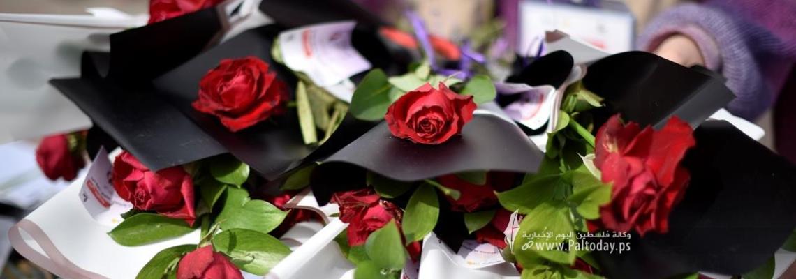 سيدات فلسطينيات يوزعن الورد على المارة على شاطىء بحر مدينة غزة خلال اليوم العالمي للمرأة