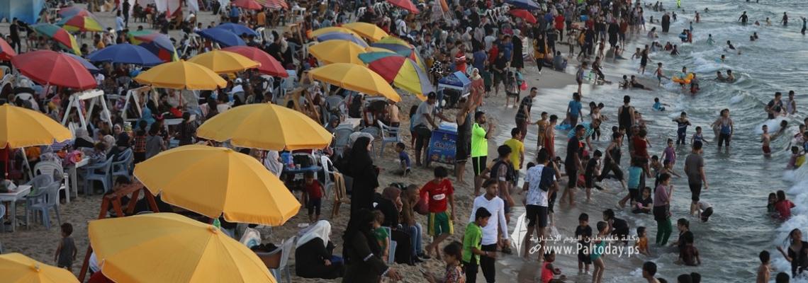 بالصور: بحر غزة يزدحم بآلاف المصطافين هرباً من حرارة الجو