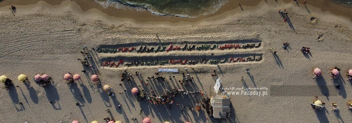 بالصور: افتتاح أكبر منحوتة رملية في فلسطين بطول 100 متر تتضمن أسماء الشهداء الأطفال في معركة وحدة الساحات.