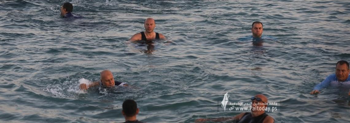 بالصور: مسنون وشباب من قطاع غزة يمارسون رياضة السباحة بمياه البحر الباردة