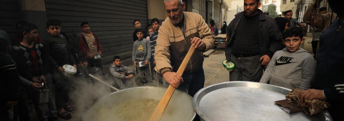 بالصور : على نار الحطب.. فلسطيني يطهو "الجريشة" لفقراء غزة بالمجان للعام التاسع على التوالي