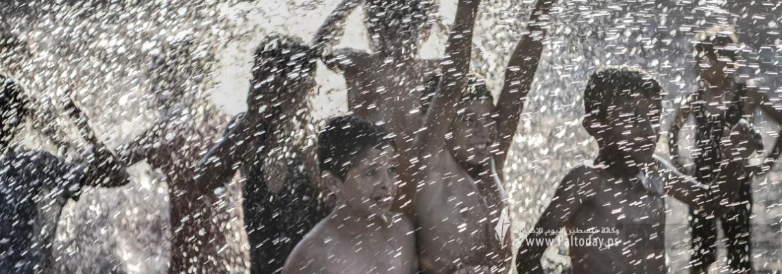 أطفال إحدى القرى النائية في قطاع غزة يخففون عن أنفسهم حرارة الجو في مسبح بالشارع .