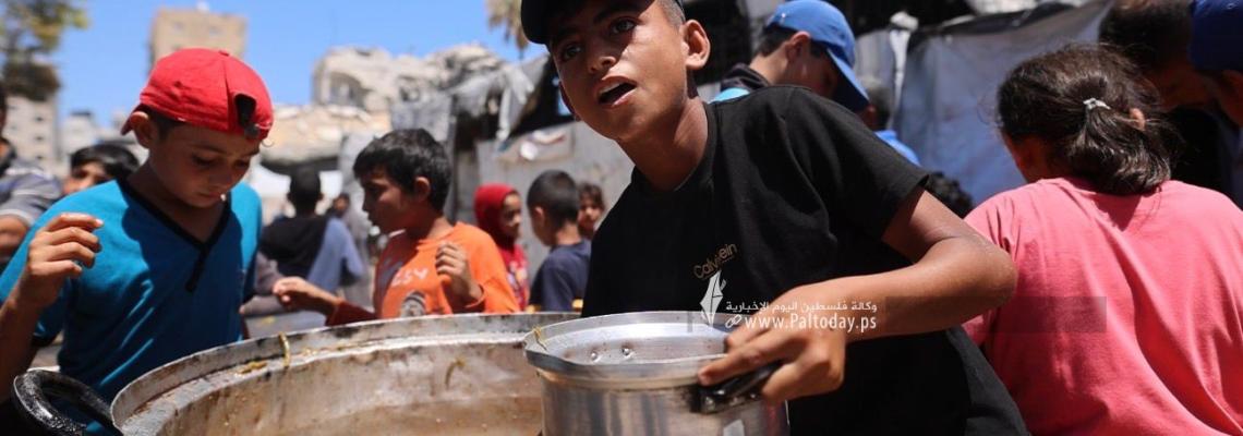 مواطنون يتجمعون أمام مطبخ خيري بانتظار استلام وجبات الطعام، في غرب مدينة غزة، في ظل استمرار الأزمة الإنسانية ونقص المواد الغذائية
