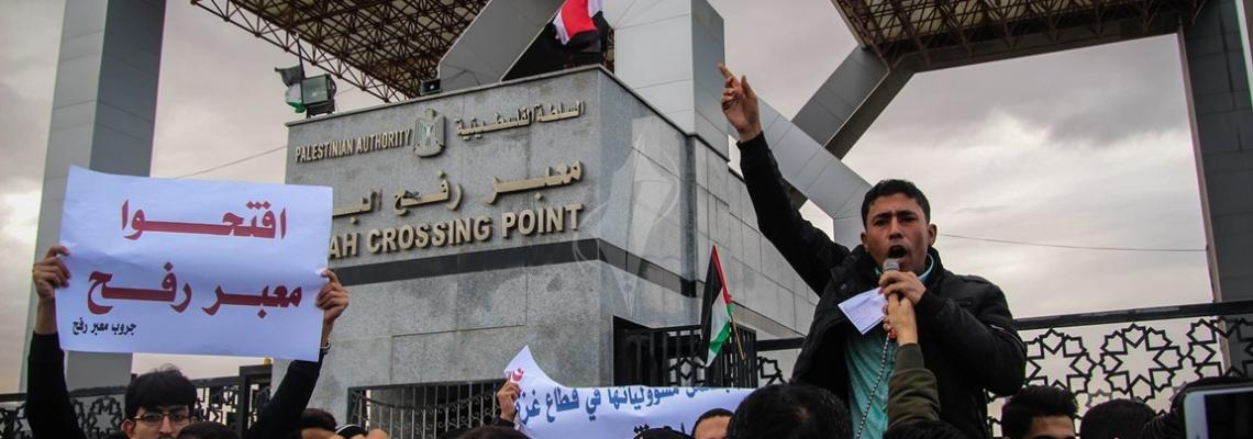 بالصور:مجموعة من الطلبة تعتصم قبالة بوابة معبر رفح البري للمطالبة بفتح المعبر.