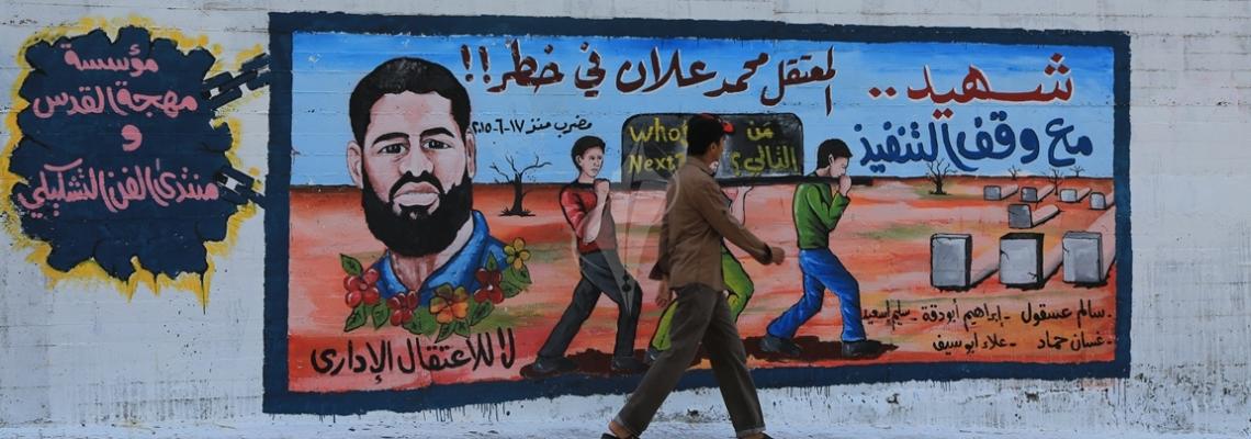 بالصور :جدارية على حائط المجلس التشريعى بغزة تضامناً مع الأسير محمد علان المضرب عن الطعام