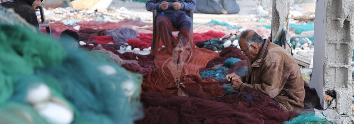بالصور:صيادون يغزلون شباكهم للاستعداد لرحلة الصيد في بحر غزة