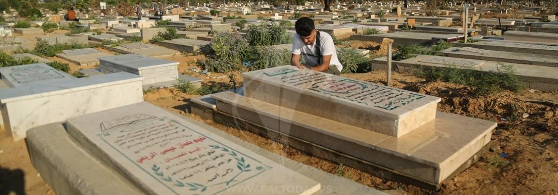 ‫أهالي الشهداء يزورون أبناءهم في المقابر في أول أيام العيد