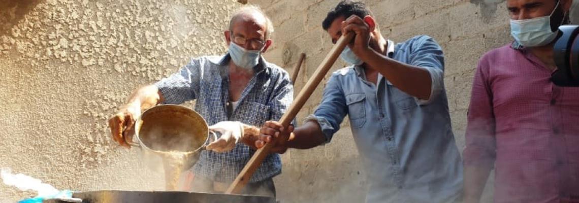 عائلة أبو طعيمة شرقي خانيونس تطهو "جريشة القمح" لتقديمها للأسر الفقيرة في ظل تفشي كورونا
