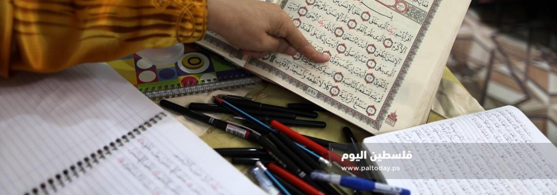 سيدة من غزة تعمل على كتابة القرآن الكريم كاملا بخط يدها