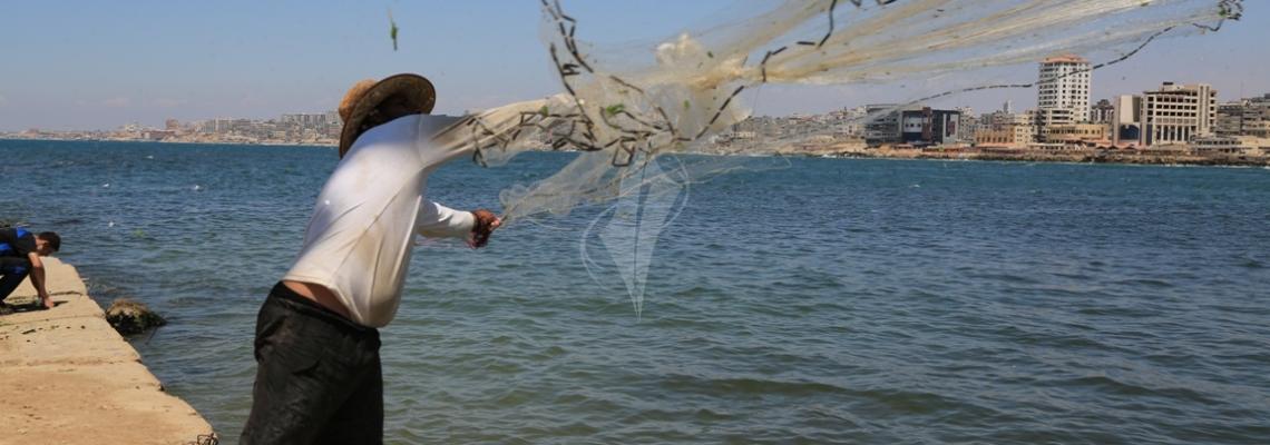 بالصور:صياد فلسطيني يبحث عن رزقه في بحر غزة في شهر رمضان المبارك