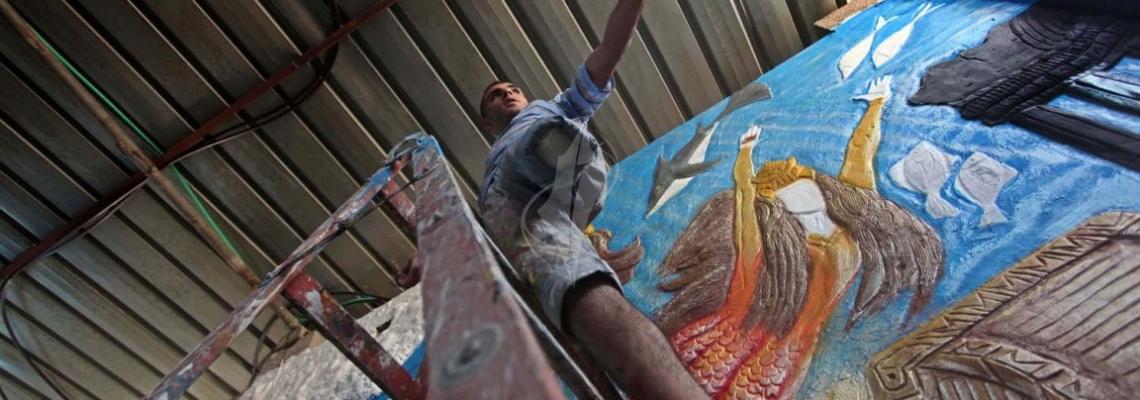 بالصور:شاب فلسطينى  بقدم واحدة يبدع فى رسم اللوحات الفنية بغزة
