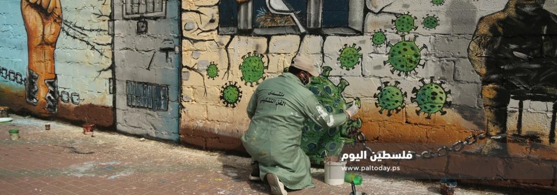 غزة: منتدى الفن التشكيلي ووزارة الاسرى يتضامنون مع الاسرى في سجون الاحتلال برسم جدارية عن فيروس كورونا
