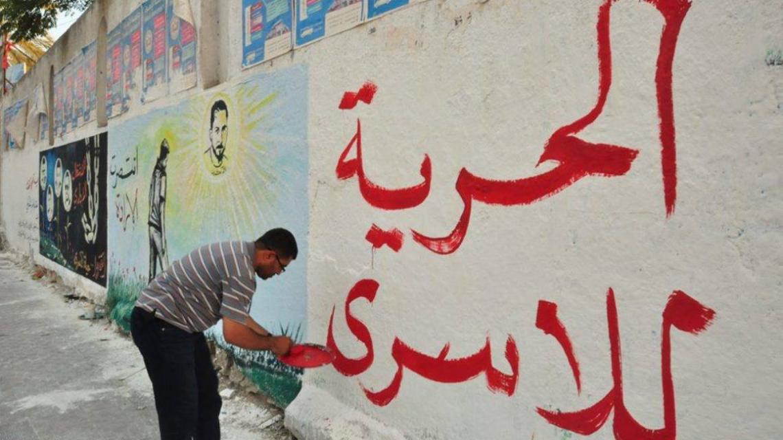 بالصور : مهجة القدس ترسم جدارية فنية على جدار جامعة الأزهر بغزة تضامنا مع الأسرى المضربين