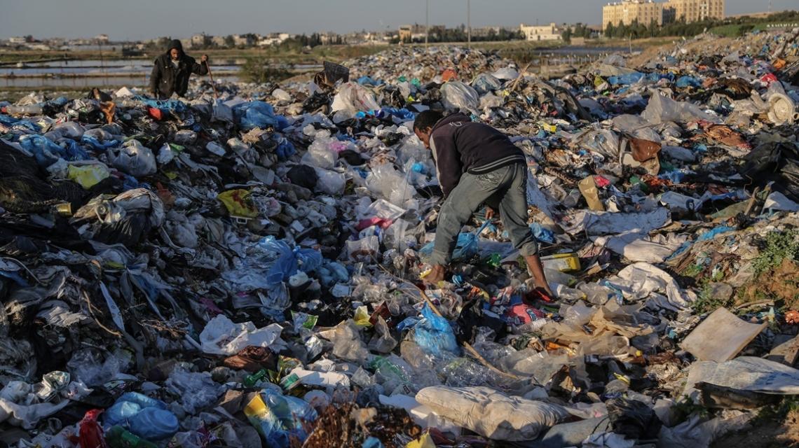 بالصور:بحثاً عن لقمة عيشه..فلسطيني يجمع البلاستيك ومواد قابلة للاستخدام  من مكب للنفايات في بلدة بيت لاهيا  شمال قطاع غزة