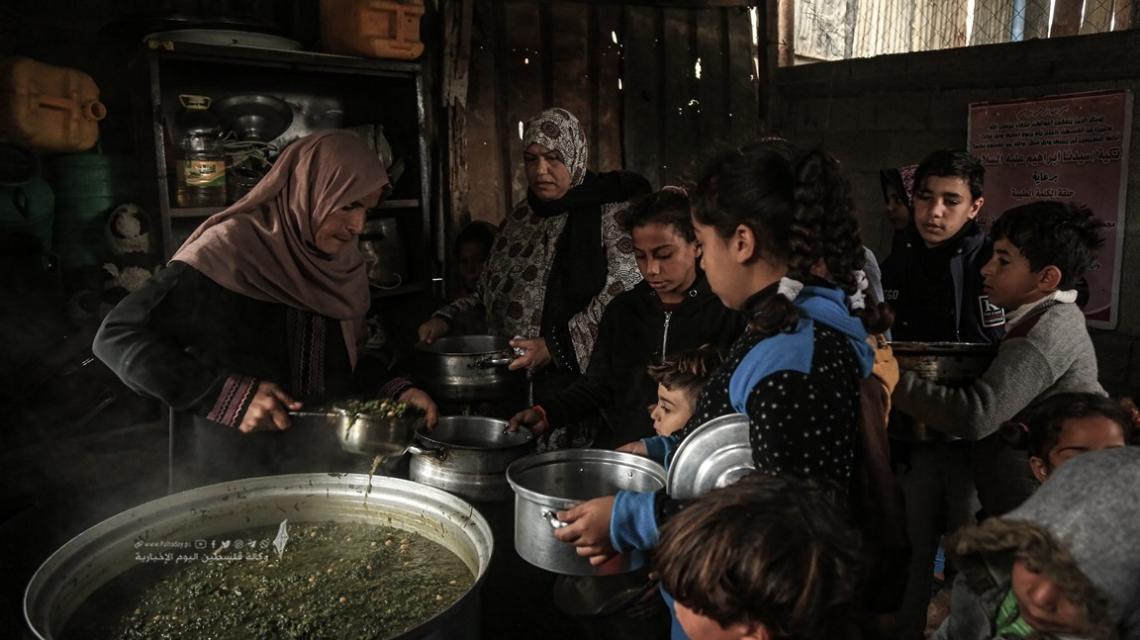 امرأة غزية تحاول تدفئة بطون الفقراء في غزة بـ"التكية"