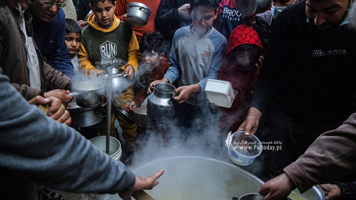 غزة..الحطاب يطهو الجريشة والعدس ويوزعها على الفقراء والمحتاجين