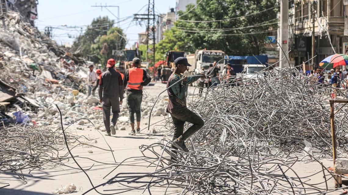 بالصور :عمال في غزة يُعيدون تدوير "حديد الأبراج السكنية" التي دمرها الاحتلال الإسرائيلي خلال معركة سيف القدس