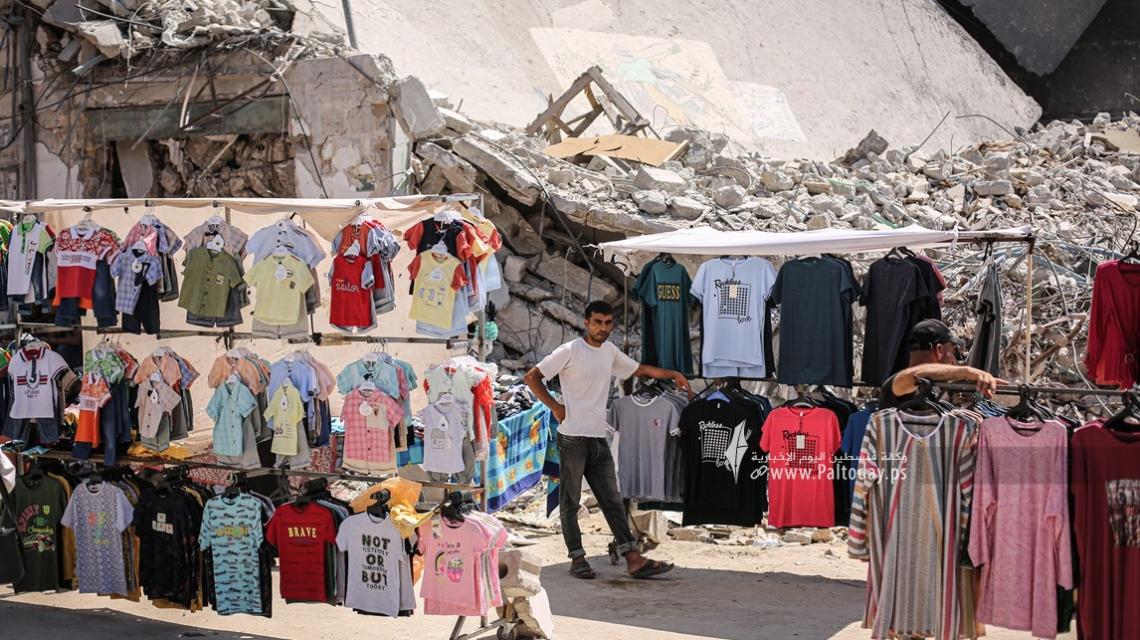 بالصور:فلسطينيون يفتتحون بسطات فوق الدمار لبيع الملابس استعدادًا لعيد الأضحى المبارك