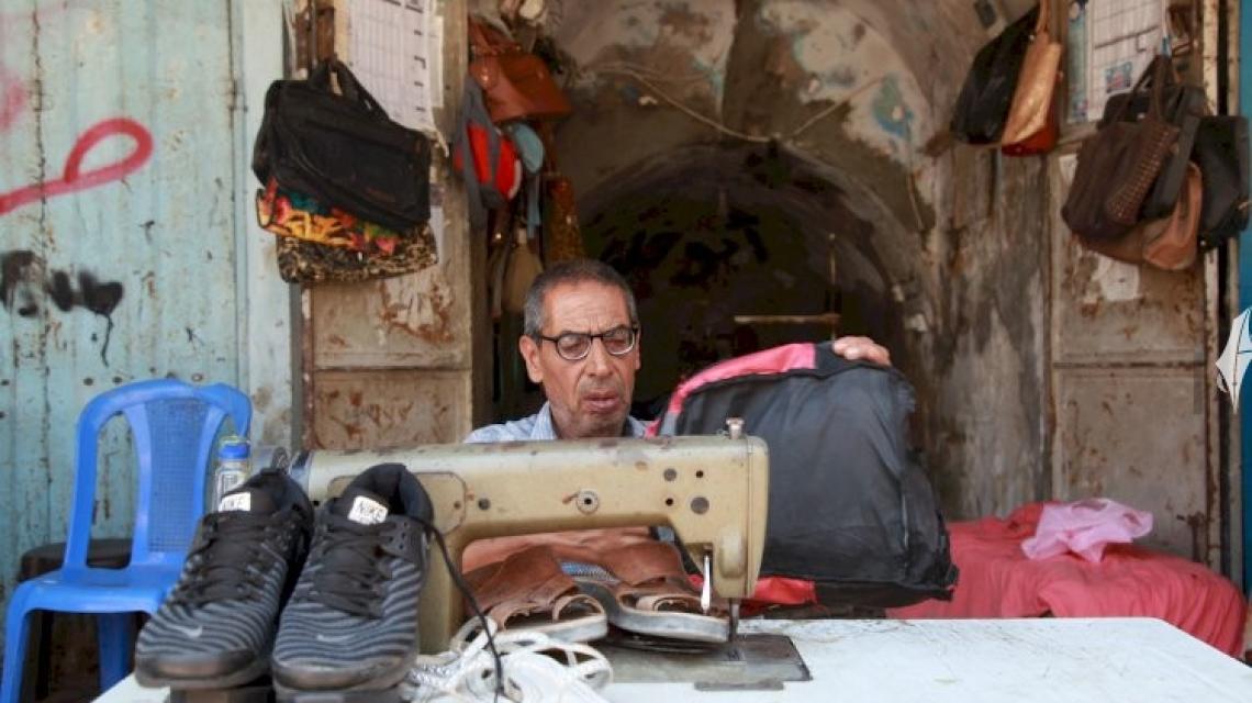 الخياط خليل حمدان يُعيد خياطة الأحذية والحقائب البالية للطلاب قبل بداية العام الدراسي الجديد