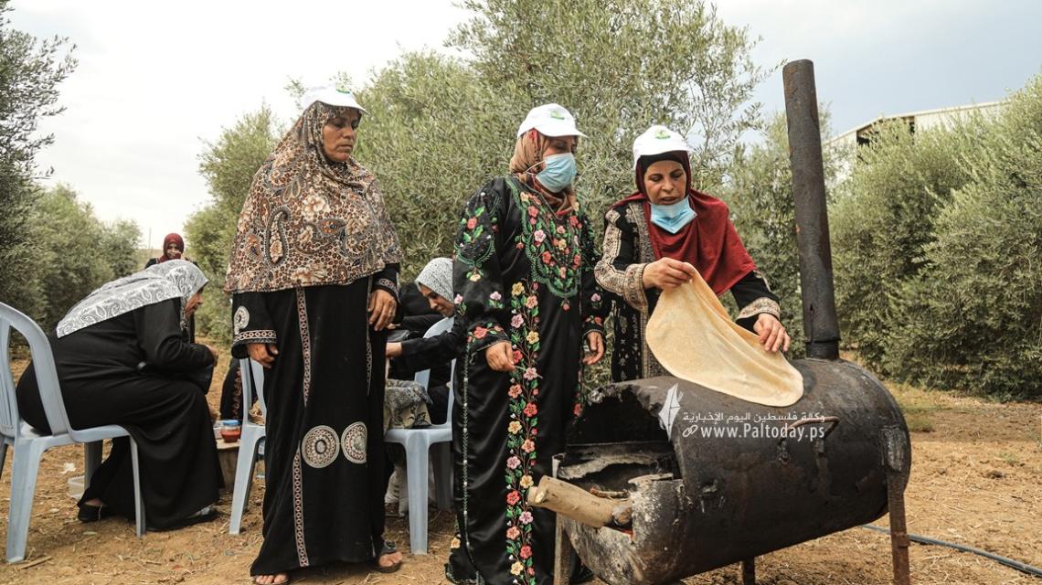 بالصور:فلسطينيات يعددن الخبز على الصاج  خلال افتتاح موسم جني الزيتون بغزة