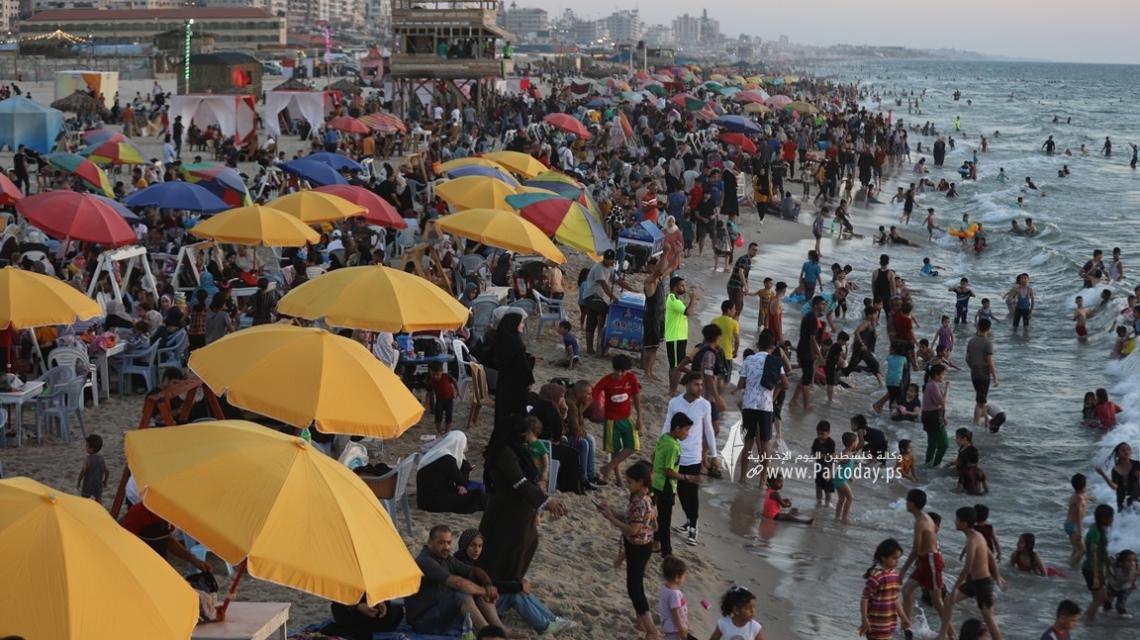 بالصور: بحر غزة يزدحم بآلاف المصطافين هرباً من حرارة الجو