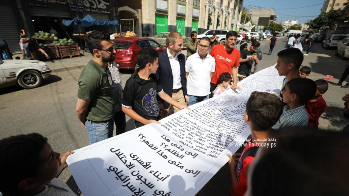 بالصور: تسليم أطول رسالة لمؤسسة دولية في غزة بمشاركة أبناء الأسرى في سجون الاحتلال