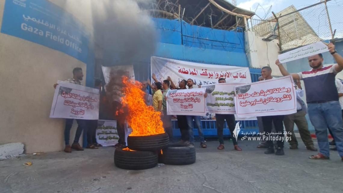 بالصور: غاضبون يلقون البيض الفاسد ويشعلون إطارات مطاطية أمام بوابة مقر وكالة "أونروا" بمدينة غزة احتجاجًا على عدم استكمال إعمار المنازل المدمرة خلال عدوان 2014