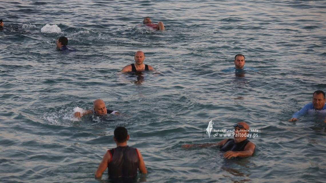 بالصور: مسنون وشباب من قطاع غزة يمارسون رياضة السباحة بمياه البحر الباردة