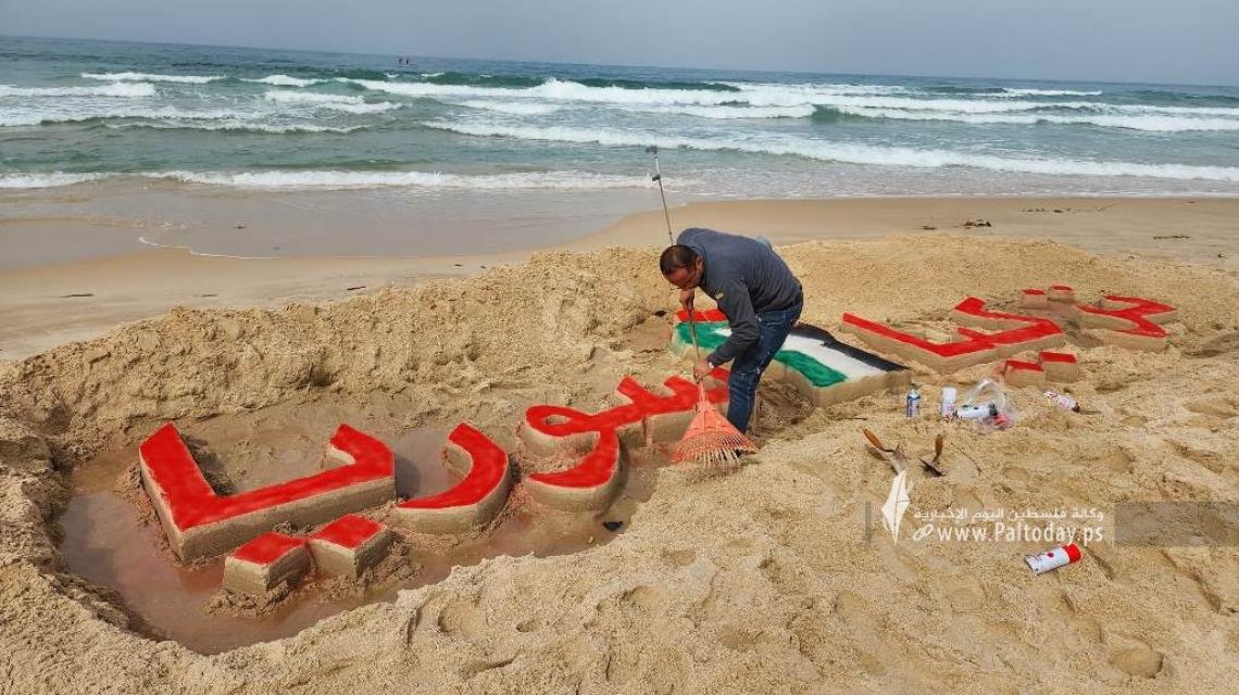 بالصور : الفنان محمد طوطح يخط على رمال شاطئ بحر غزة أسماء دولتي تركيا وسوريا تضامنًا معهما بعد الزلزال المدمر