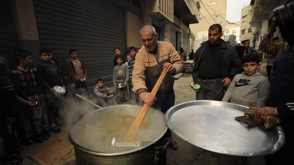 بالصور : على نار الحطب.. فلسطيني يطهو "الجريشة" لفقراء غزة بالمجان للعام التاسع على التوالي