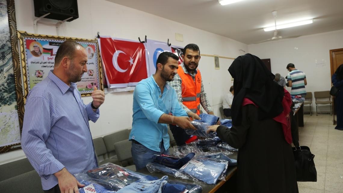 بالصور:العمل النسائي بالتعاون مع جمعية أرض السلام توزع كسوة العيد لمئات الأطفال بغزة