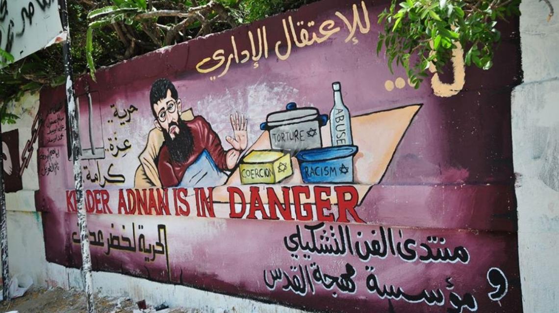 بالصور:لوحة جدارية فنية اسناداً لإضراب الشيخ خضر عدنان تنظمها مهجة القدس أمام مقر الصليب بغزة