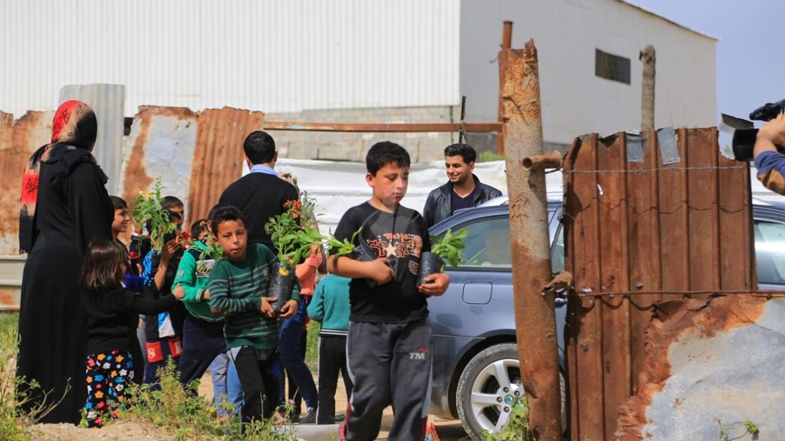 بالصور:أطفال غزة يزرعون الورود على ركام المنازل المدمرة خلال الحرب الأخيرة