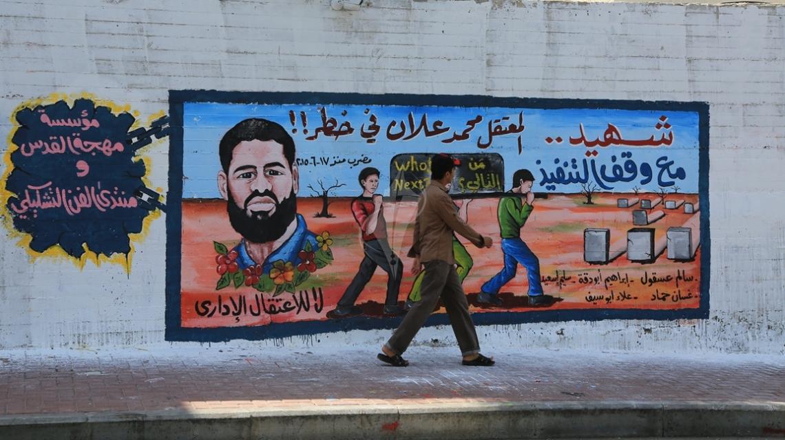 بالصور :جدارية على حائط المجلس التشريعى بغزة تضامناً مع الأسير محمد علان المضرب عن الطعام
