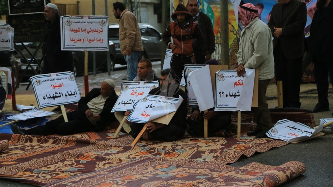 بالصور:أهالي الشهداء في غزة يطالبون بحقوقهم المالية من أمام مقر الصليب الأحمر