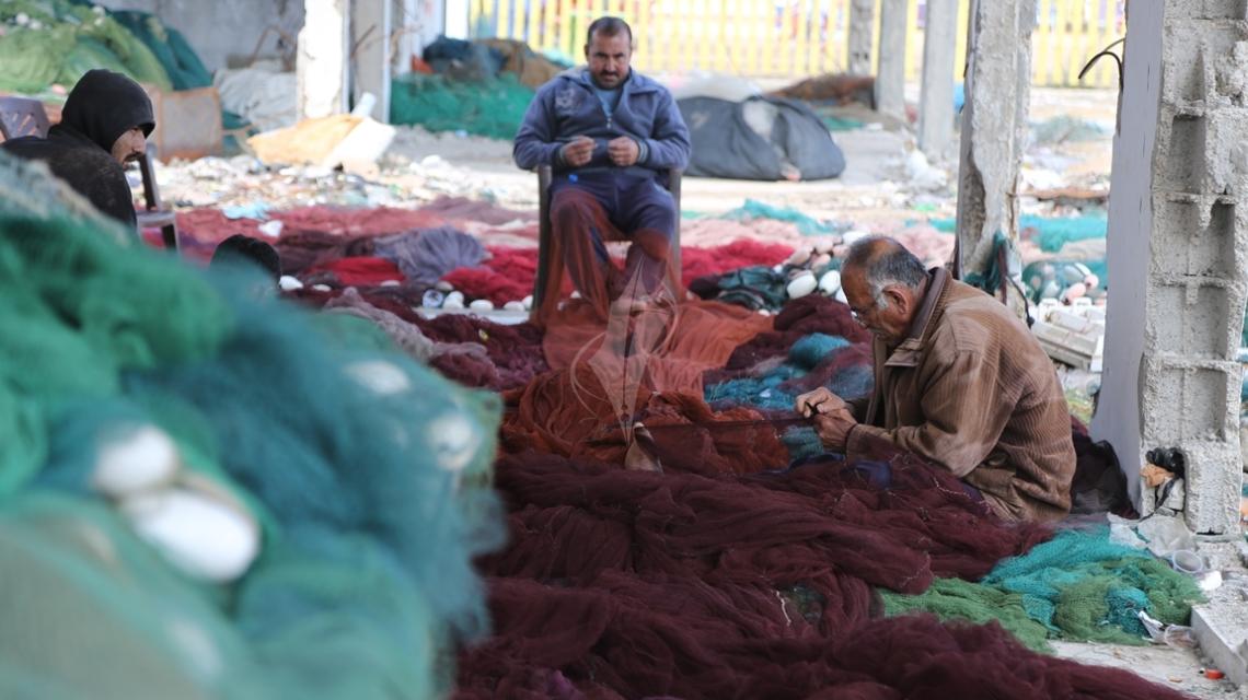 بالصور:صيادون يغزلون شباكهم للاستعداد لرحلة الصيد في بحر غزة