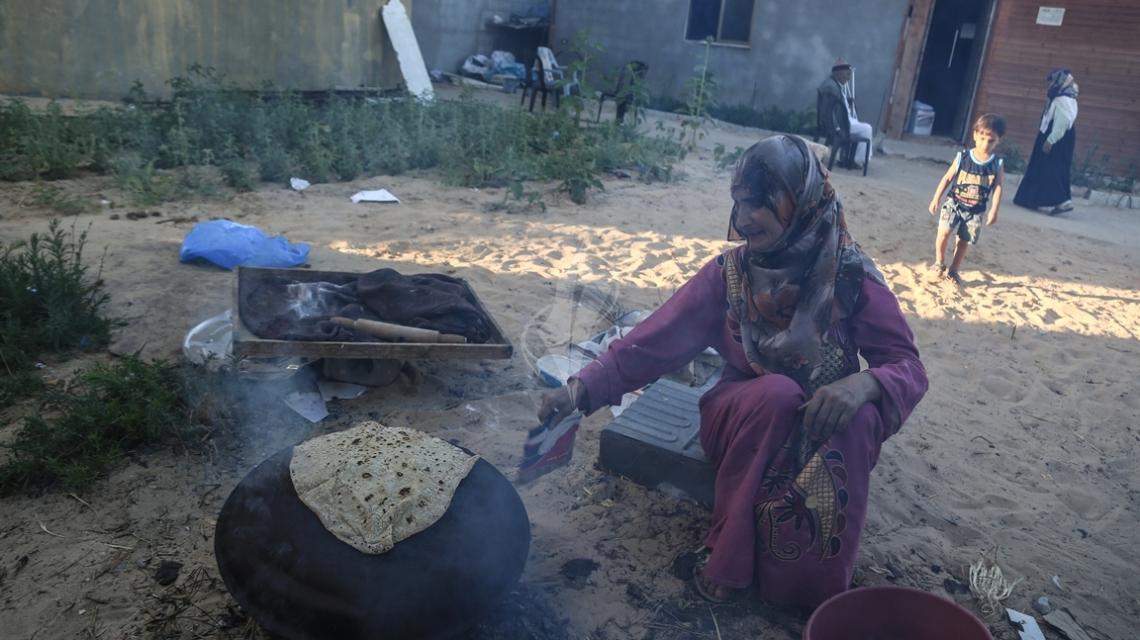 بالصور:سيدة فلسطينية من منطقة الزنة شرق خانيونس تلجأ الى الخبز على الافران القديمة فى شهر رمضان المبارك فى ظل تواصل ازمة الكهرباء
