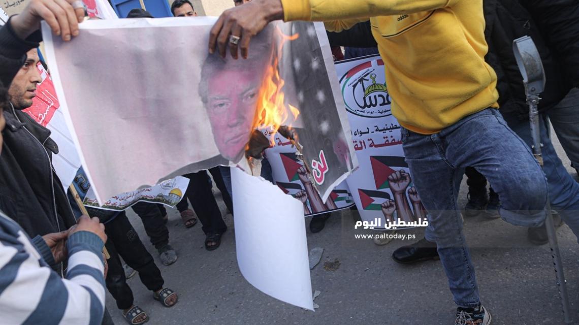 متظاهرون فلسطينيون يحرقون صوراً لنتنياهو وترامب في وقفة رافضة لصفقة القرن وسط قطاع غزة