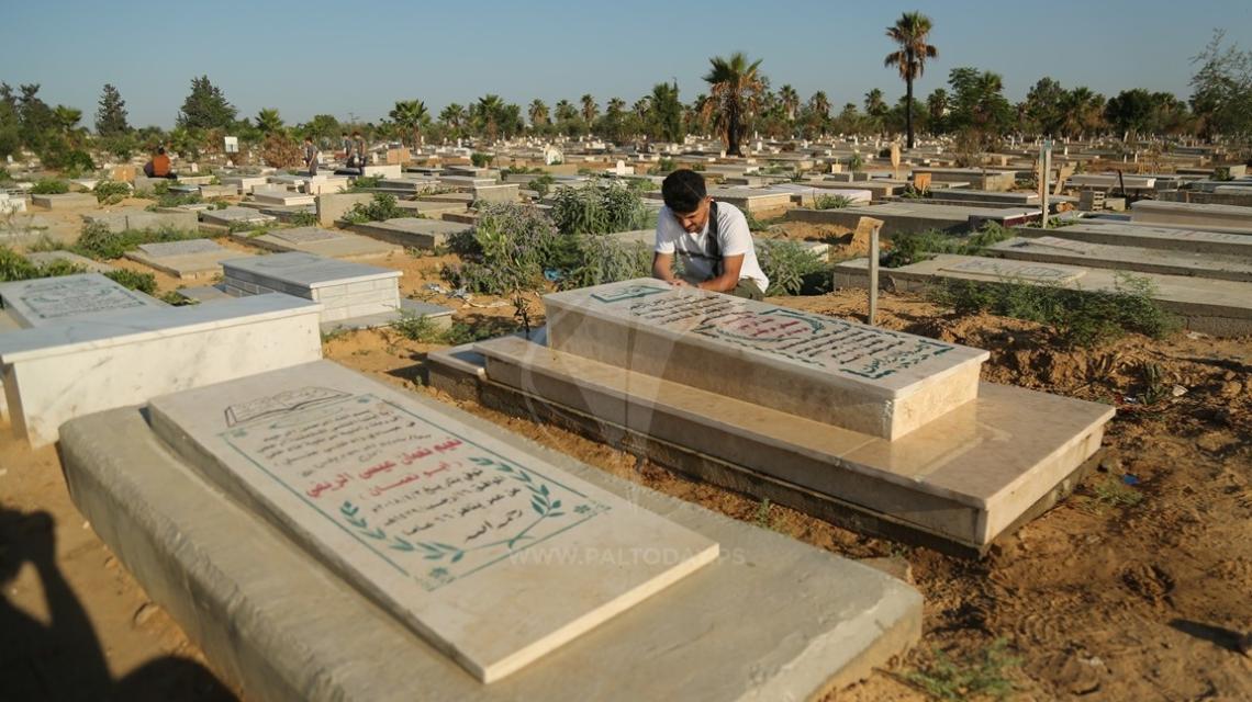 ‫أهالي الشهداء يزورون أبناءهم في المقابر في أول أيام العيد