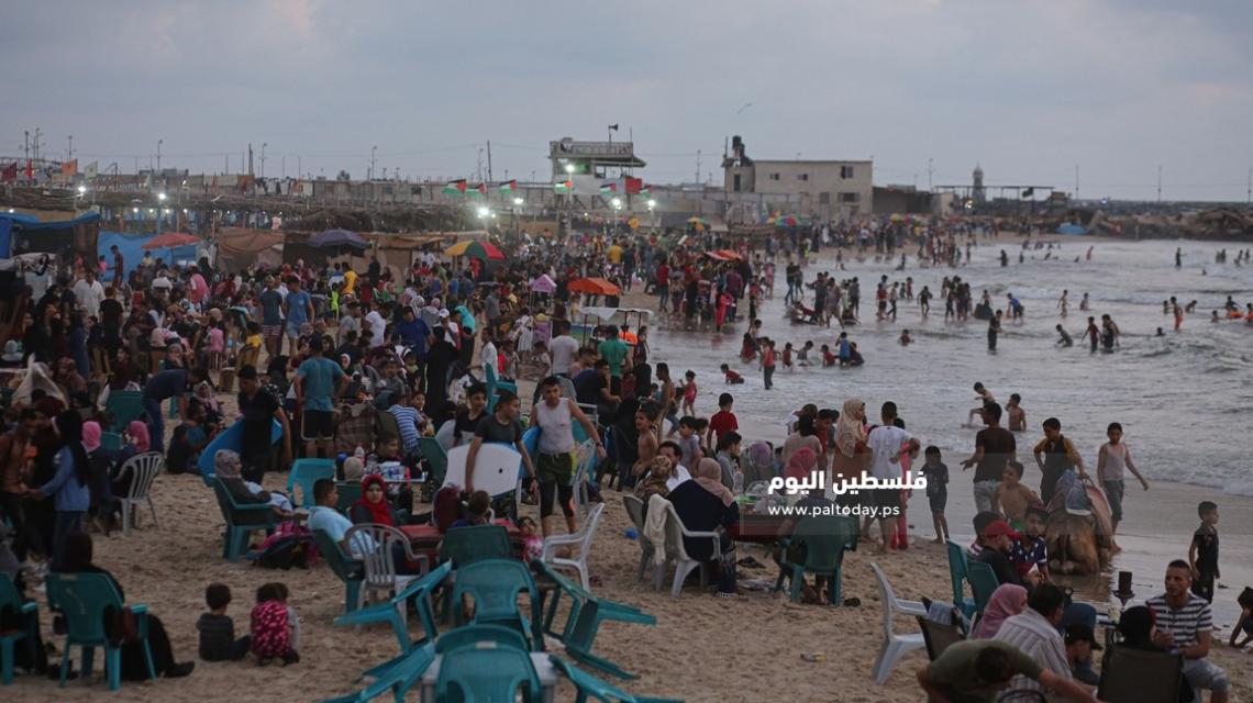 الغزيون يهربون إلى شواطئ بحر غزة من حرارة الجو وانقطاع التيار الكهربائي