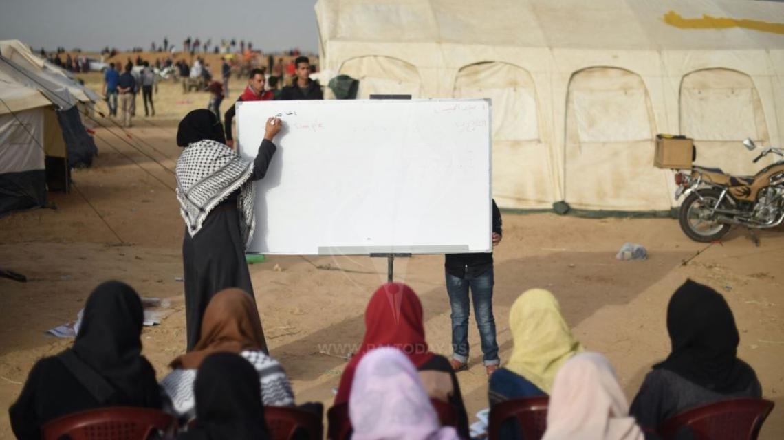 المعلمة وسام ابو طعيمة تعطى دروس تقوية داخل مخيم العودة فى بلدة خزاعة جنوب القطاع