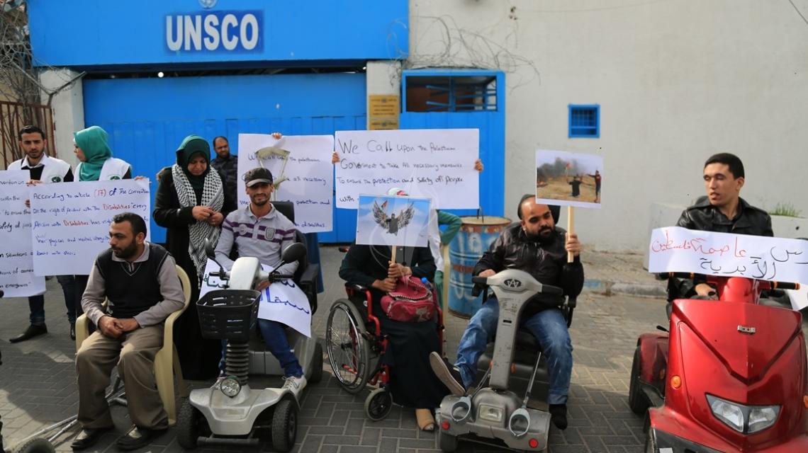 بالصور:فلسطينيون من ذوي الإعاقة ينددون باستهداف الاحتلال المقعد أبو ثريا في وقفة أمام مقر "اليونسكو" بغزة